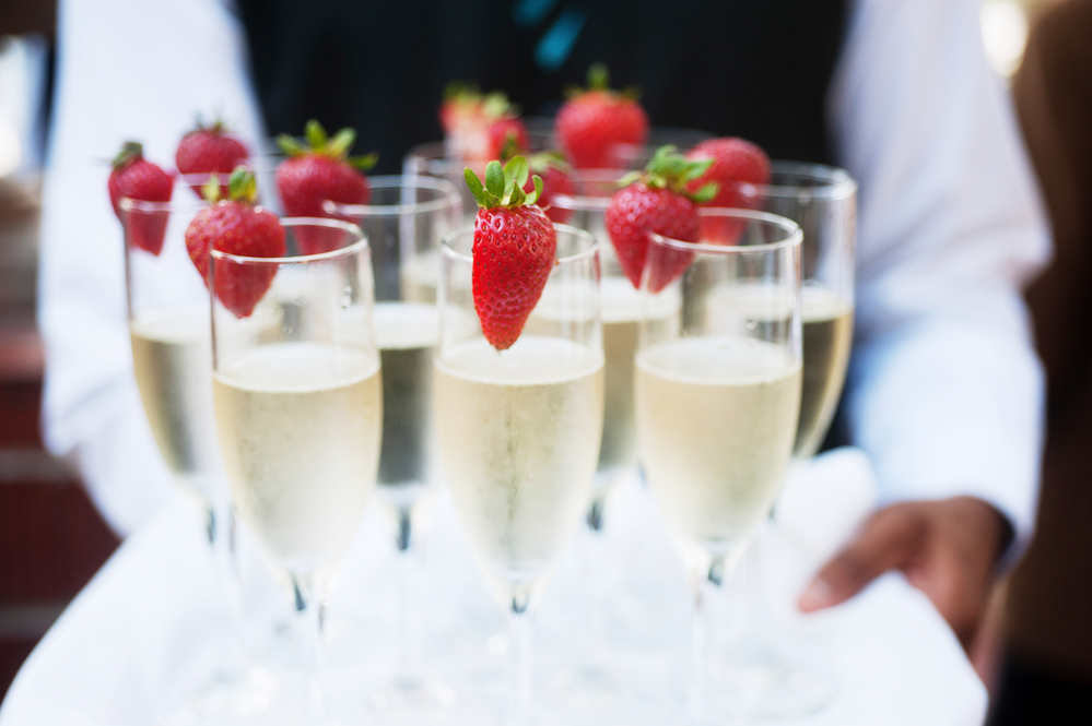 Waiter serving champagne on a tray Waiter serving champagn with strawberries
